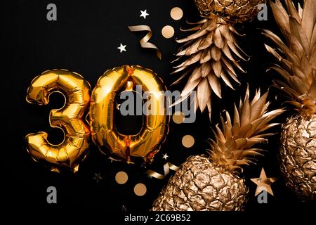 30th birthday celebration background with gold balloons and golden pineapples Stock Photo