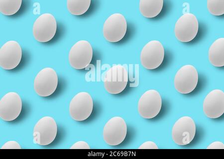 Easter white eggs with shadows on blue background. Pattern, hipster design. Flat lay. Stock Photo