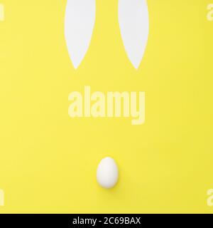 Easter bunny bback view on yellow background. Ears and tail from egg. Minimal easter concept Stock Photo