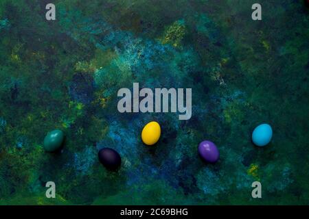 Color easter eggs on blue oil paint mixed background. Easter hipster concept. Copy space. Stock Photo
