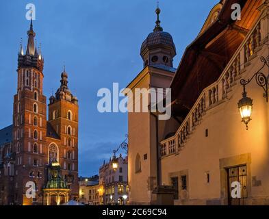 Krakow Basilica and corner of the Cloth Hall with illuminated lamp at dawn. Stock Photo