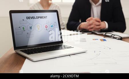 Laptop With Business Development Scheme On Screen In Modern Office Stock Photo