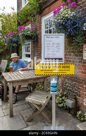 Pubs have reopened in England after coronavirus covid-19 restrictions have eased, 7 July 2020, UK. Pub with hand wash station and safety signs outside