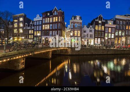 AMSTERDAM, NETHERLANDS - 16TH FEBRUARY 2016: A view along the Keizersgracht canal in Amsterdam at night. Reflections, buildings, bikes and cars can be Stock Photo