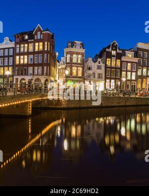 AMSTERDAM, NETHERLANDS - 16TH FEBRUARY 2016: A view along the Keizersgracht canal in Amsterdam at night. Buildings, bridges, cars and bikes can be see Stock Photo