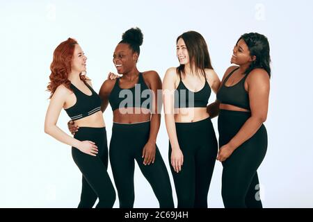 Group of women of different race, figure type and size in sportswear  standing together over brown background. Diverse women in sports clothing  looking Stock Photo - Alamy