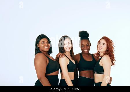 black woman smiling with a group of gym people on the background