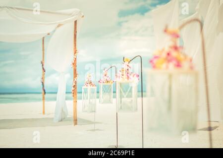 Romantic beach ceremony setup with colorful sky. Luxury beach wedding, honeymoon or anniversary concept Stock Photo
