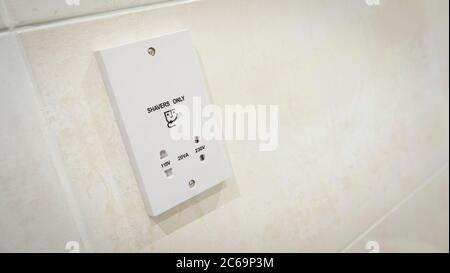 Shaver point on the tiled wall of a contemporary bathroom. Stock Photo