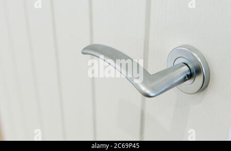 Close up of a metal lever door handle in a contemporary house. Stock Photo