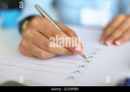 Woman fills out questionnaire by ticking document. Stock Photo
