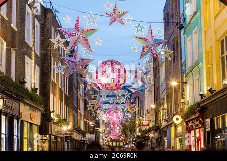 LONDON, UK - 23RD DECEMBER 2015: A view along Carnaby Street during the Christmas period, showing the outside of buildings, decorations and people. Stock Photo