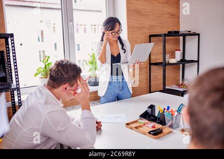 Businesss for people. Young asian female wearing formalwear stand giving speech, multi-ethnic group of people listen to her, successful public speech. Stock Photo