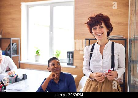 Beautiful caucasian woman present master class using flipchart to diverse foreign listeners, african listener Stock Photo