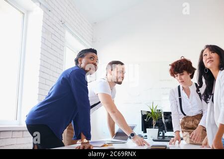 Interracial business team friendly work together in office, discussing new business ideas. Stock Photo
