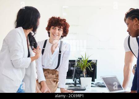 Young team of international people take rest after discussing business ideas in office, smile laugh together, happy Stock Photo