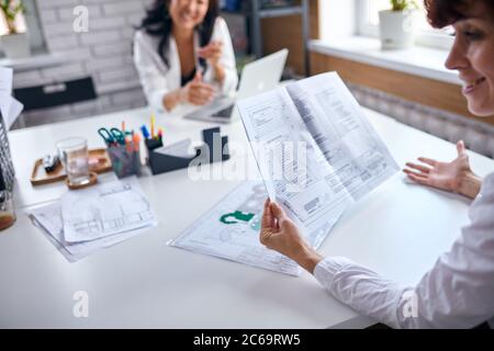 Beautiful asian director of company listen to caucasian representative holding papers Stock Photo