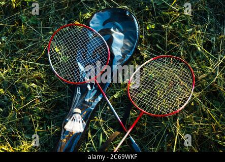 Two crossed badminton racquets on a grass. Sport and summer outdoor activities Stock Photo