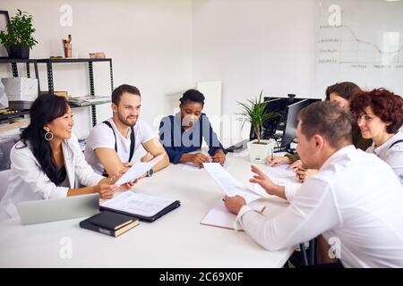 Multiethnic business team conducted negotiations in office , have conversation and discuss. White interior modern office. Business for people Stock Photo