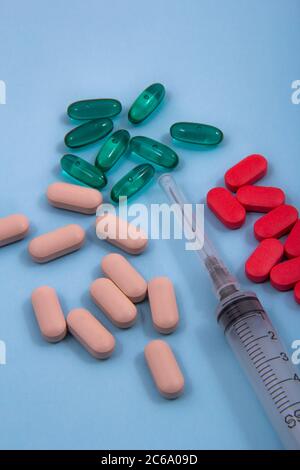 Top view of pills and capsules outside the package next to equipment and medical devices. Stock Photo