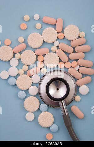 Top view of pills and capsules outside the package next to equipment and medical devices. Stock Photo