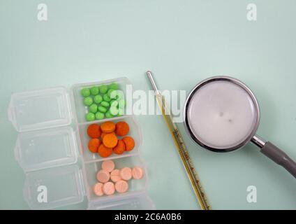 Top view of pills and capsules outside the package next to equipment and medical devices. Stock Photo