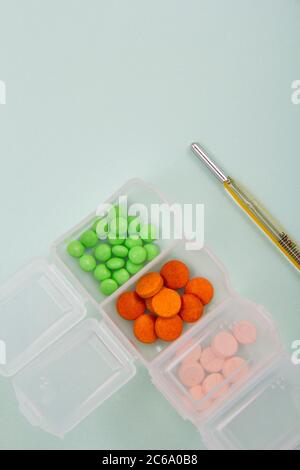 Colored tablets and capsules out of the package. Colored tablets and capsules along with medical supplies. Stock Photo