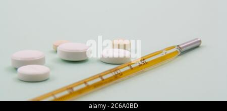 Top view of pills and capsules outside the package next to equipment and medical devices. Stock Photo