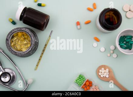 Top view of pills and capsules outside the package next to equipment and medical devices. Stock Photo