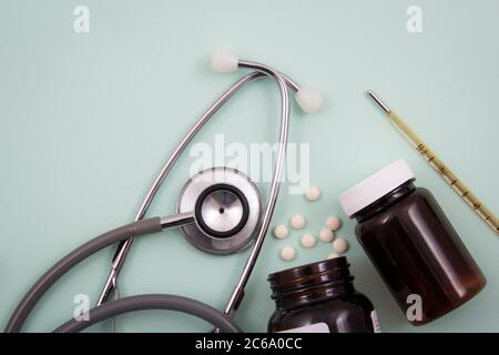 Top view of pills and capsules outside the package next to equipment and medical devices. Stock Photo