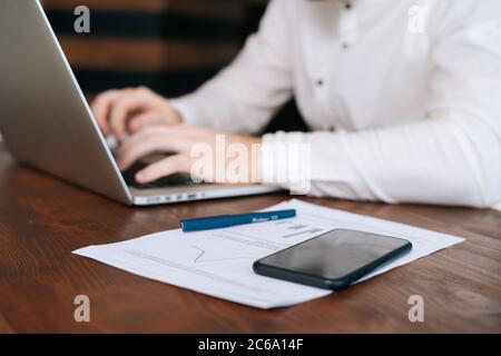 Close-up view of unrecognizable busy young businessman is working on laptop computer Stock Photo