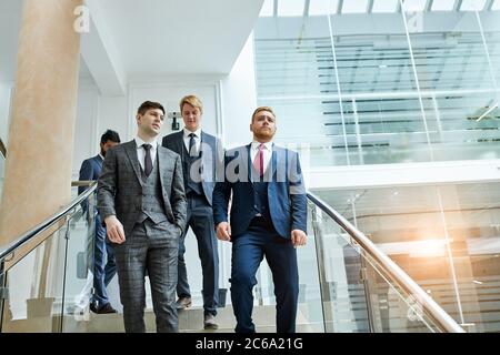Caucasian men go speaking, having conversation after conference. Business center background Stock Photo