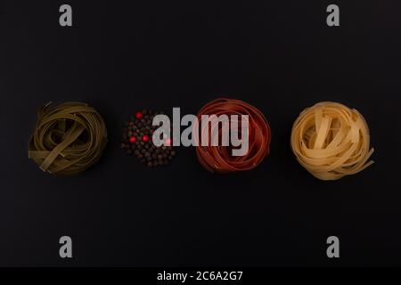 Shaped and colorful pasta in different sizes and colors in small dishes together at close range. Stock Photo