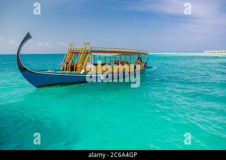 Maldives island background, amazing exotic landscape of blue turquoise sea view with horizon and wooden boat from Maldives, Dhoni. Sea tourism Stock Photo