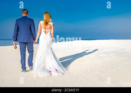 Just married couple walking on tropical beach. Exotic wedding destination. Wedding romantic couple on the beach Stock Photo