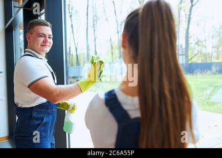 team of cleaners make spring cleaning in new house. Two janitors in uniform Stock Photo