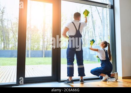 team of cleaners make spring cleaning in new house. Two janitors in uniform Stock Photo