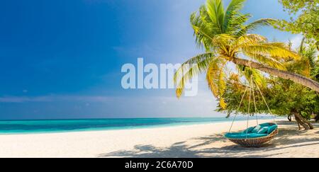 Tropical beach panorama as summer landscape with beach swing or hammock and white sand and calm sea for beach banner. Perfect beach scene vacation Stock Photo