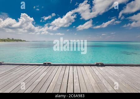 Wooden table top on blue sea and tropical island beach background. Luxury summer travel and vacation concept. Exotic holiday design Stock Photo