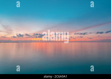 Calm sea with sunset sky and sun through the clouds over. Meditation ocean and sky background. Tranquil seascape. Horizon over the water. Stock Photo