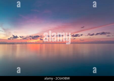 Calm sea with sunset sky and sun through the clouds over. Meditation ocean and sky background. Tranquil seascape. Horizon over the water. Stock Photo