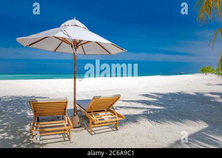 Beach chairs with umbrella over white sand and sea view. Tropical travel, vacation summer holiday. Exotic nature beach landscape Stock Photo