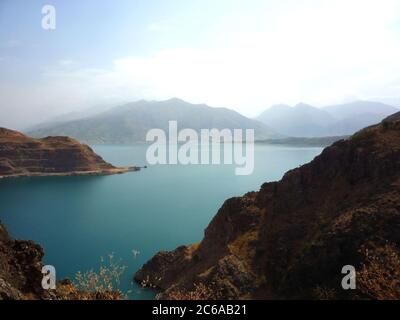 Beautiful lake Charvak, with blue water in the mountains of Uzbekistan. Beautiful lake on the background of mountains. Stock Photo