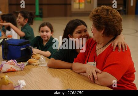 Austin Texas USA, November 2003: Grandmother visits her granddaughter during lunchtime at small private parochial Catholic school.  ©Bob Daemmrich Stock Photo