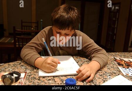 Nine-and-a-half year old Anglo boy 4th grader completes a homework assignment.  MR ©Bob Daemmrich Stock Photo