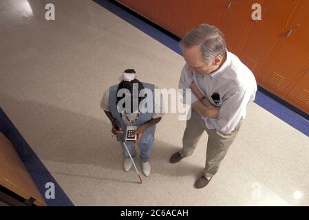 Austin, Texas USA, 2002: Blind student uses infrared guide device to help her get around at the Texas School for the Blind while instructor looks on. ©Bob Daemmrich Stock Photo