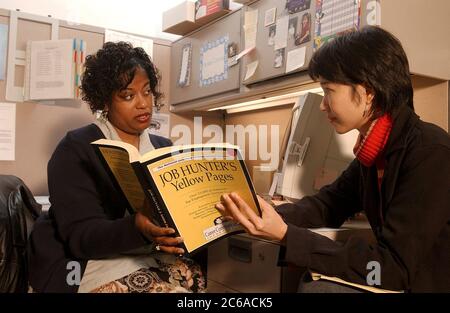 Austin Texas USA, January 16, 2002: Black female caseworker  at the Capital of Texas Workforce Commission, talks to young Asian-American job-seeker.   MR  ©Bob Daemmrich Stock Photo