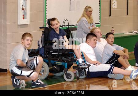 Mabank, Texas USA, September 10, 2003: 12-year-old boy with cerebral palsy and learning disability waits on sidelines with teammates during gym class, mainstreamed with other children. MODEL RELEASE SP-71 (boy in wheelchair). Others not released.  ©Bob Daemmrich Stock Photo