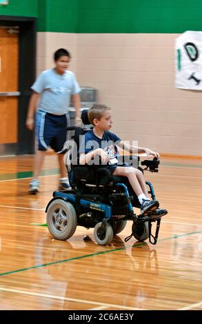 Mabank, Texas USA, September 10, 2003: 12-year-old boy with cerebral palsy and learning disability plays 'flag tag' in gym class, mainstreamed with other children. MODEL RELEASE SP-71 (boy in wheelchair). Others not released.  ©Bob Daemmrich Stock Photo