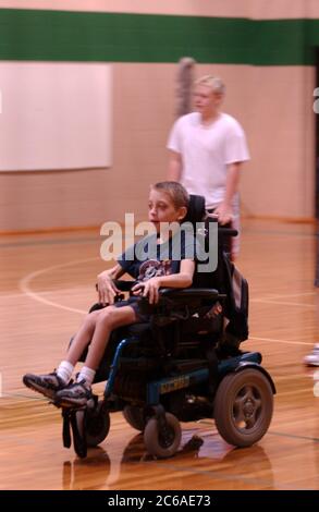 Mabank, Texas USA, September 10, 2003: 12-year-old boy with cerebral palsy and learning disability plays 'flag tag' in gym class, mainstreamed with other children. MODEL RELEASE SP-71 (boy in wheelchair). Others not released.  ©Bob Daemmrich Stock Photo